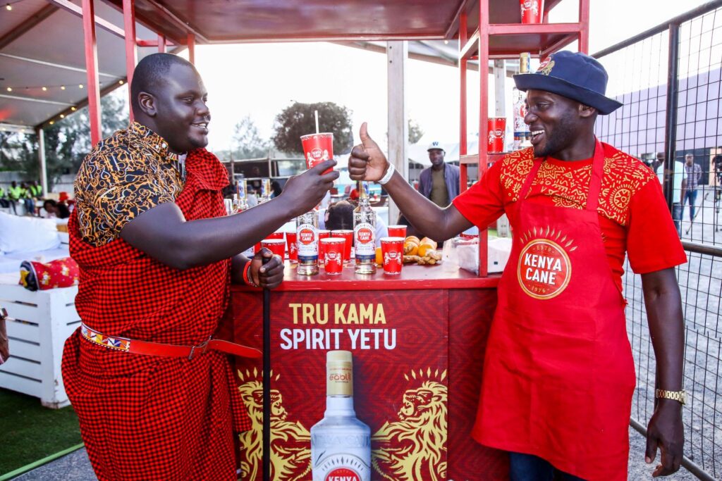 Kenya Cane Brand Manager Davis Changalwa(L) receives a KC uzalendo cocktail from Mixologist Chris Kantai